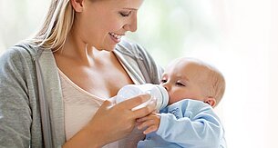 Eine Frau füttert ihr Baby mit der Flasche.