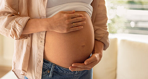 Eine schwangere Frau in einem Zimmer.