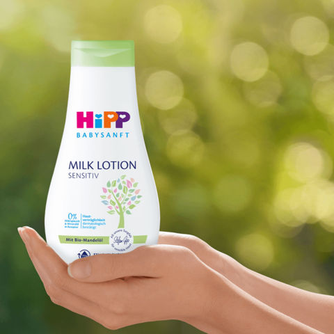 Eine Flasche 'Hipp Baby Sanft' Milchlotion, die ihre Empfindlichkeit und die Tatsache, dass sie 0% veriglickkt ist, hervorhebt.