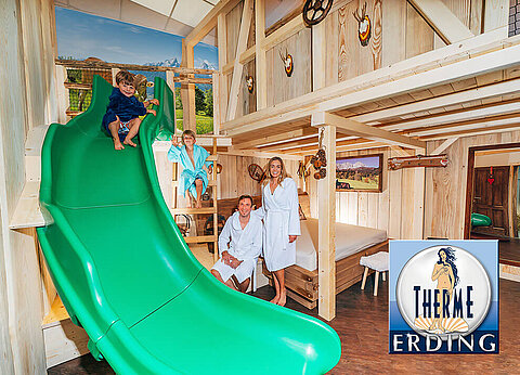 Eine Familie in einem hölzernen Raum mit einer Rutsche und dem Logo der Therme Erding in der unteren rechten Ecke.