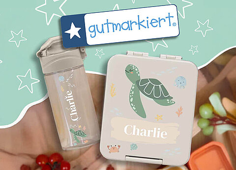 Personalisierte Wasserflasche und Lunchbox mit Meerestiermotiven und dem Namen "Charlie" auf türkisfarbenem Hintergrund mit weißen Sternenmustern.