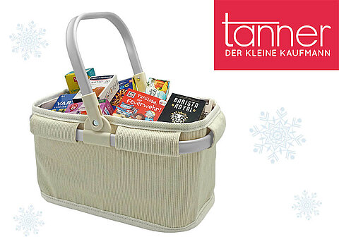 Eine beigefarbene Tragetasche, gefüllt mit verschiedenen Produkten, ist vor einem weißen Hintergrund mit Schneeflocken platziert, begleitet von dem roten Logo von "tanner" oben rechts.