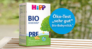 Eine Produktbox mit der Aufschrift "BIO" und dem Text "Allerwichtige und beste Zutaten aus der Natur". Außerdem gibt es einen blauen Kreis mit dem Text "Öko-Test", gefolgt von "Bio-Babymilch".