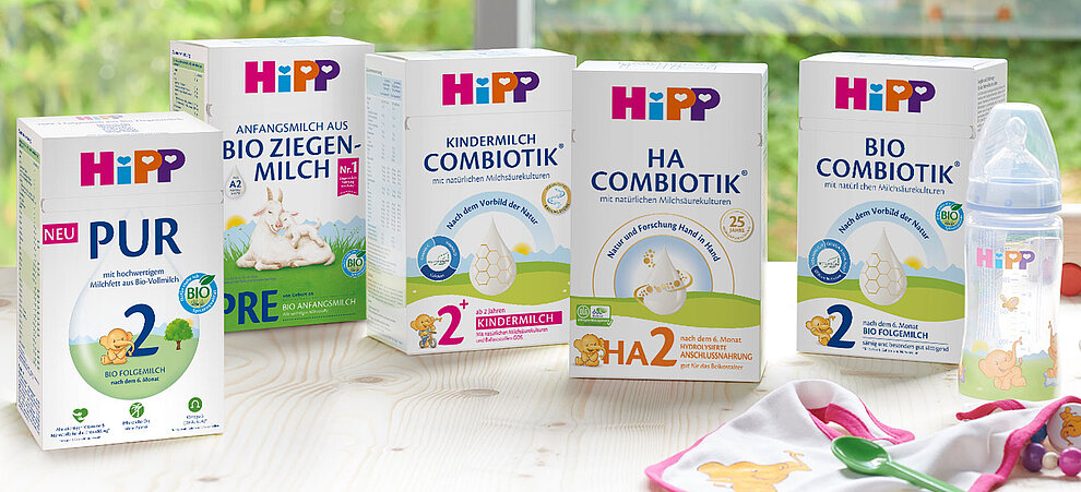 Eine Reihe von Säuglingsmilchprodukten der Marke "HiPP", darunter "BIO ZIEGEN-MILCH", "KINDERMILCH", "HA COMBIOTIK" und "BIO FOLGEMILCH". Jedes Produkt ist mit seinem Entwicklungsstadium, seinem Nährstoffgehalt und seinen Inhaltsstoffen gekennzeichnet.