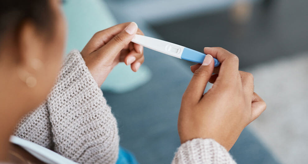 Eine Person hält einen Ovulationstest in der Hand.