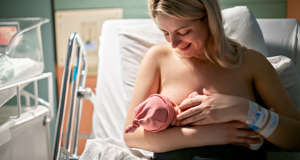 Ein zärtlicher Moment zwischen einer Mutter und ihrem neugeborenen Baby in einem Krankenhaus.